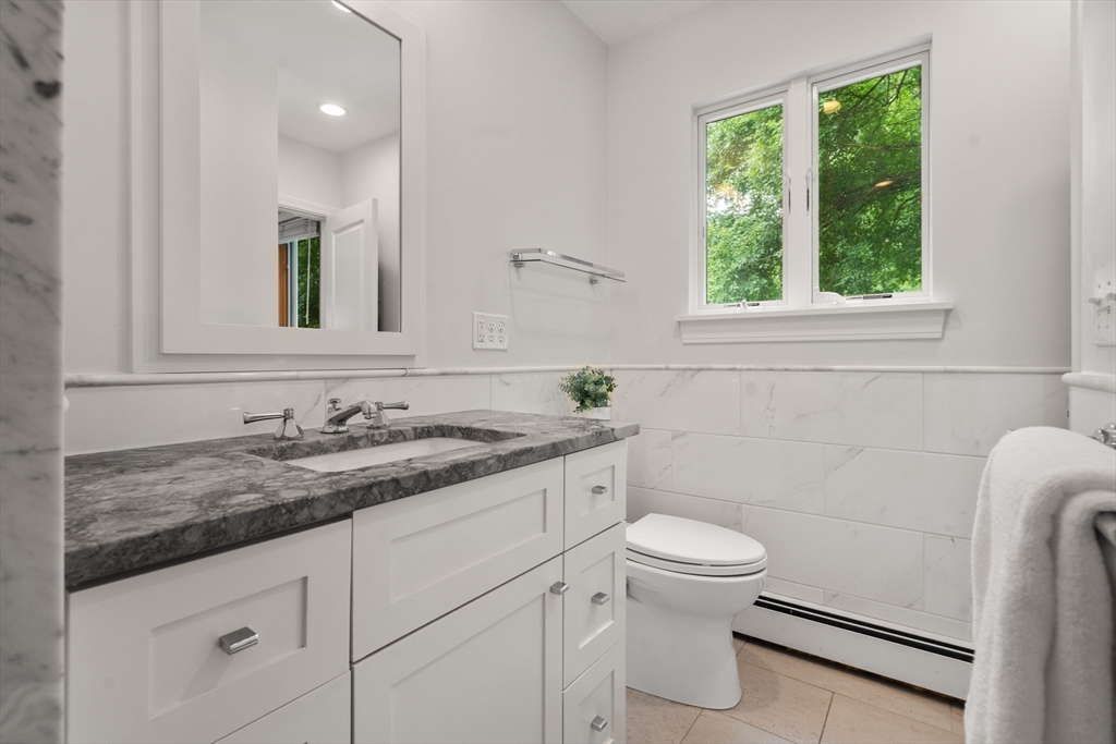 83 Bound Brook Road Newton, MA 02461 - Photo 14 of 21 a bathroom with a granite countertop bathtub sink vanity mirror and toilet