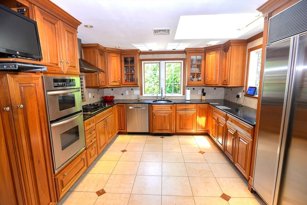 31 Sumner Road Brookline, MA 02445 - Photo 3 of 26 a kitchen with stainless steel appliances granite countertop a stove a sink and a refrigerator