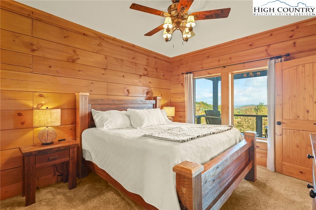 584 Grey Fox Ridge Road Banner Elk, NC 28604 - Photo 16 of 50 a bed room with a bed and a chandelier