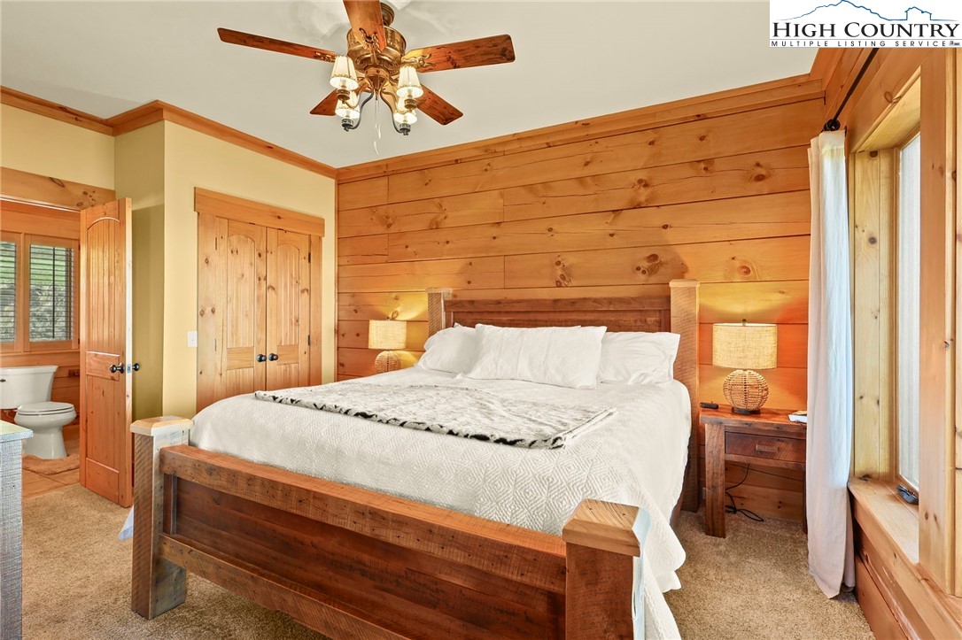 584 Grey Fox Ridge Road Banner Elk, NC 28604 - Photo 17 of 50 a bedroom with a bed and a chandelier