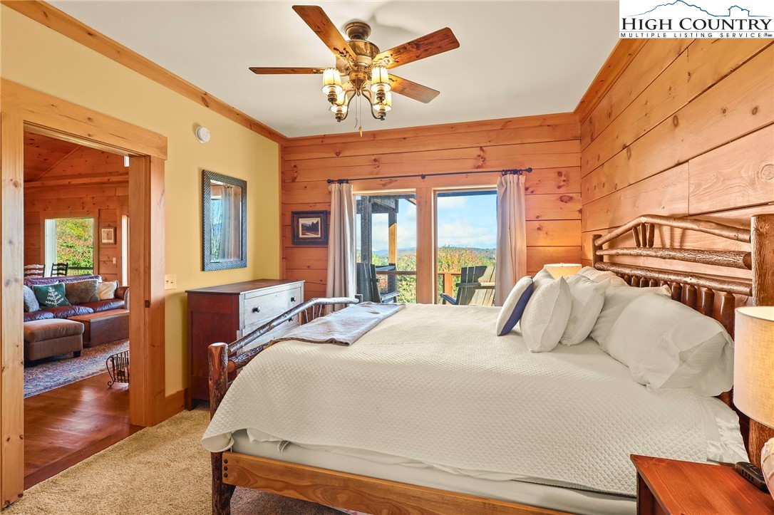 584 Grey Fox Ridge Road Banner Elk, NC 28604 - Photo 20 of 50 a bedroom with a large bed and a chandelier