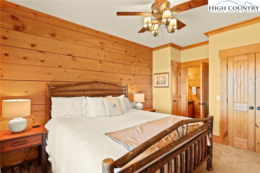 584 Grey Fox Ridge Road Banner Elk, NC 28604 - Photo 22 of 50 a bedroom with a bed and a chandelier