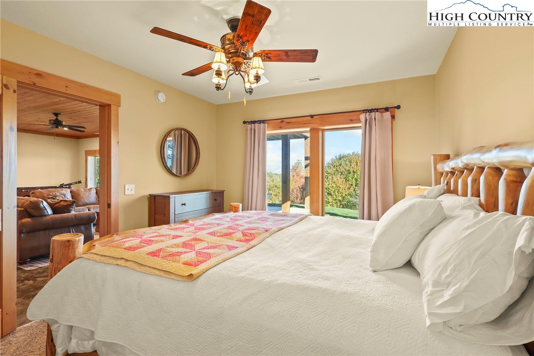 584 Grey Fox Ridge Road Banner Elk, NC 28604 - Photo 29 of 50 a bedroom with a large bed and a chandelier