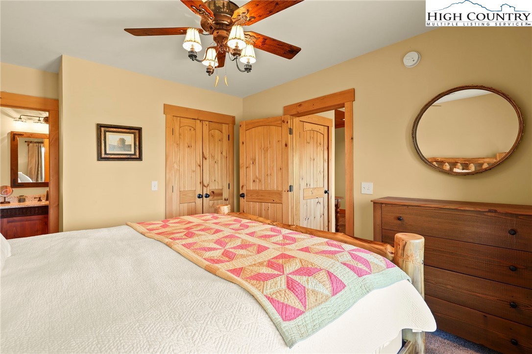 584 Grey Fox Ridge Road Banner Elk, NC 28604 - Photo 31 of 50 a bedroom with a bed and a chandelier