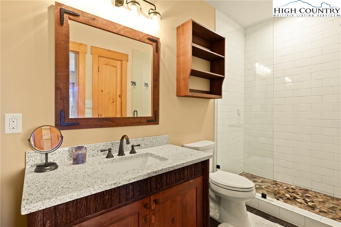 584 Grey Fox Ridge Road Banner Elk, NC 28604 - Photo 33 of 50 a bathroom with a granite countertop sink and a mirror