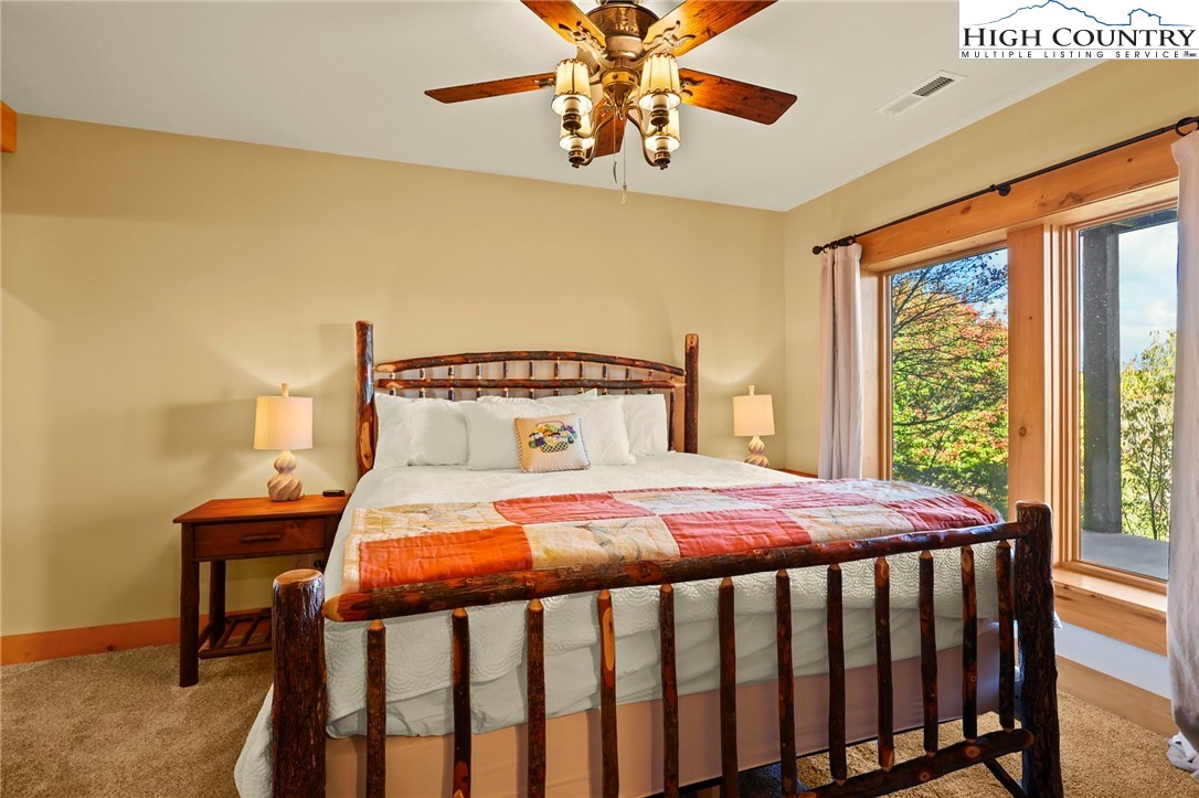 584 Grey Fox Ridge Road Banner Elk, NC 28604 - Photo 35 of 50 a bedroom with a bed and a chandelier