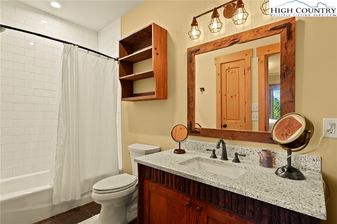 584 Grey Fox Ridge Road Banner Elk, NC 28604 - Photo 36 of 50 a bathroom with a granite countertop sink a toilet and shower