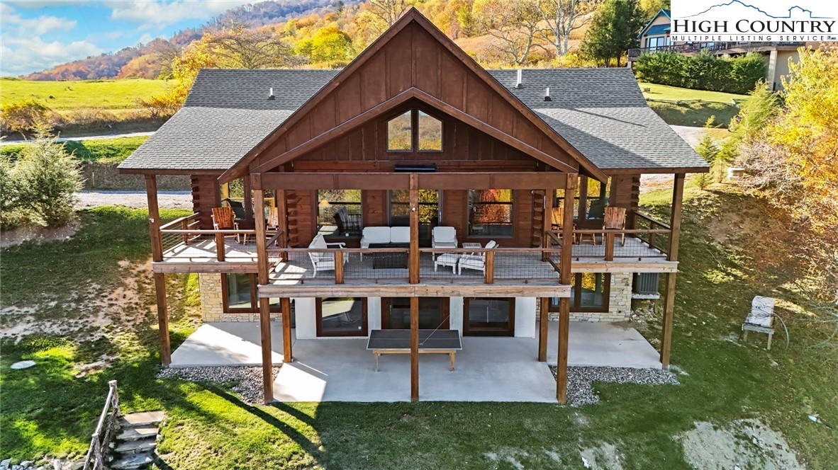 584 Grey Fox Ridge Road Banner Elk, NC 28604 - Photo 39 of 50 a view of a patio with table and chairs potted plants and a palm tree