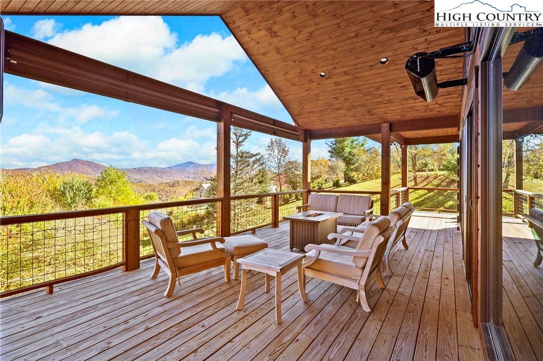 584 Grey Fox Ridge Road Banner Elk, NC 28604 - Photo 6 of 50 a roof deck with table and chairs and wooden floor