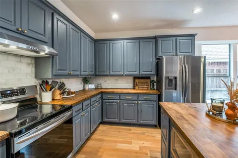 a kitchen with stainless steel appliances granite countertop a refrigerator a stove and a sink