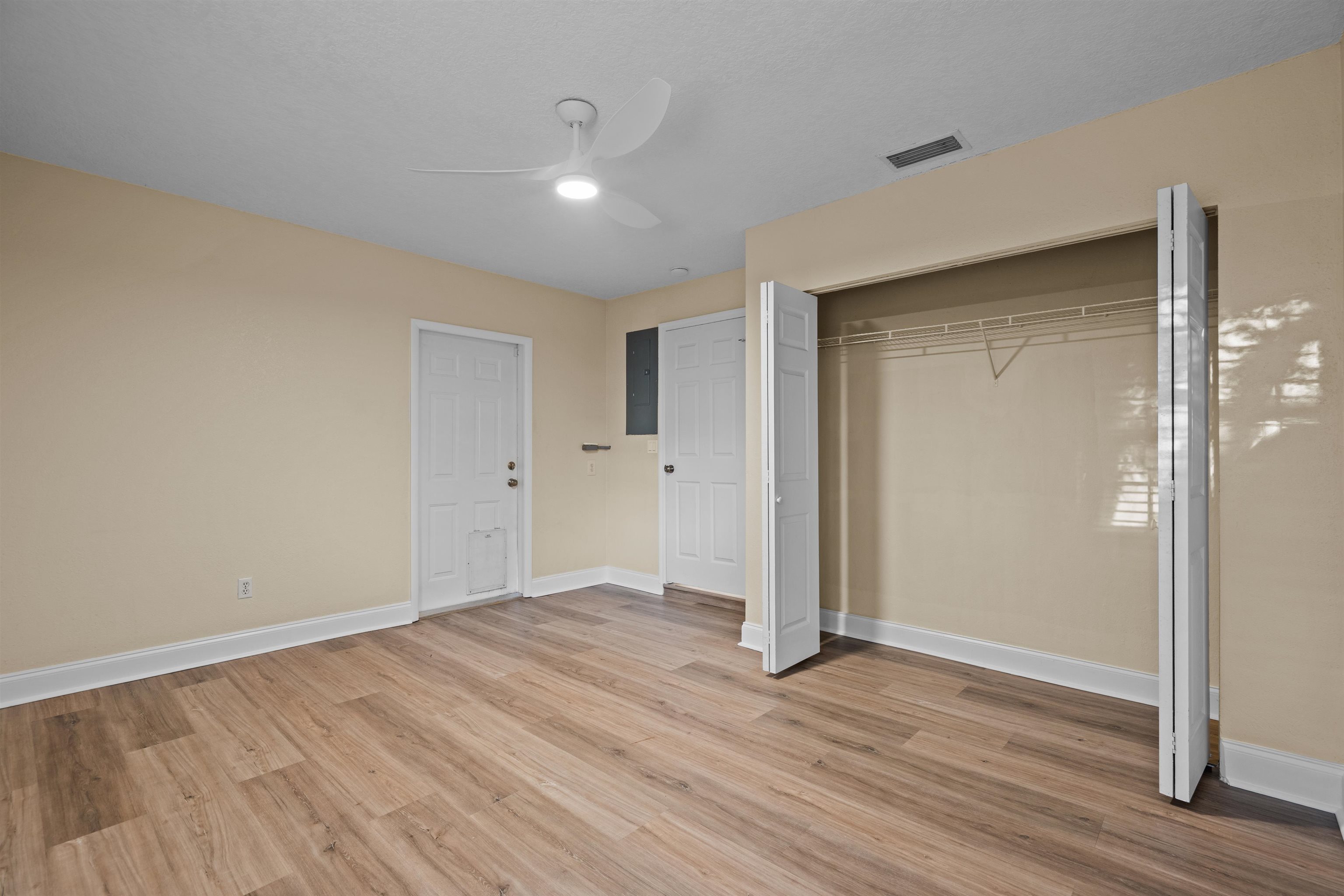 285 Trillo Street St. Augustine, FL 32086 - Photo 12 of 48 Unfurnished bedroom featuring a closet, a ceiling fan, light wood finished floors, and electric panel