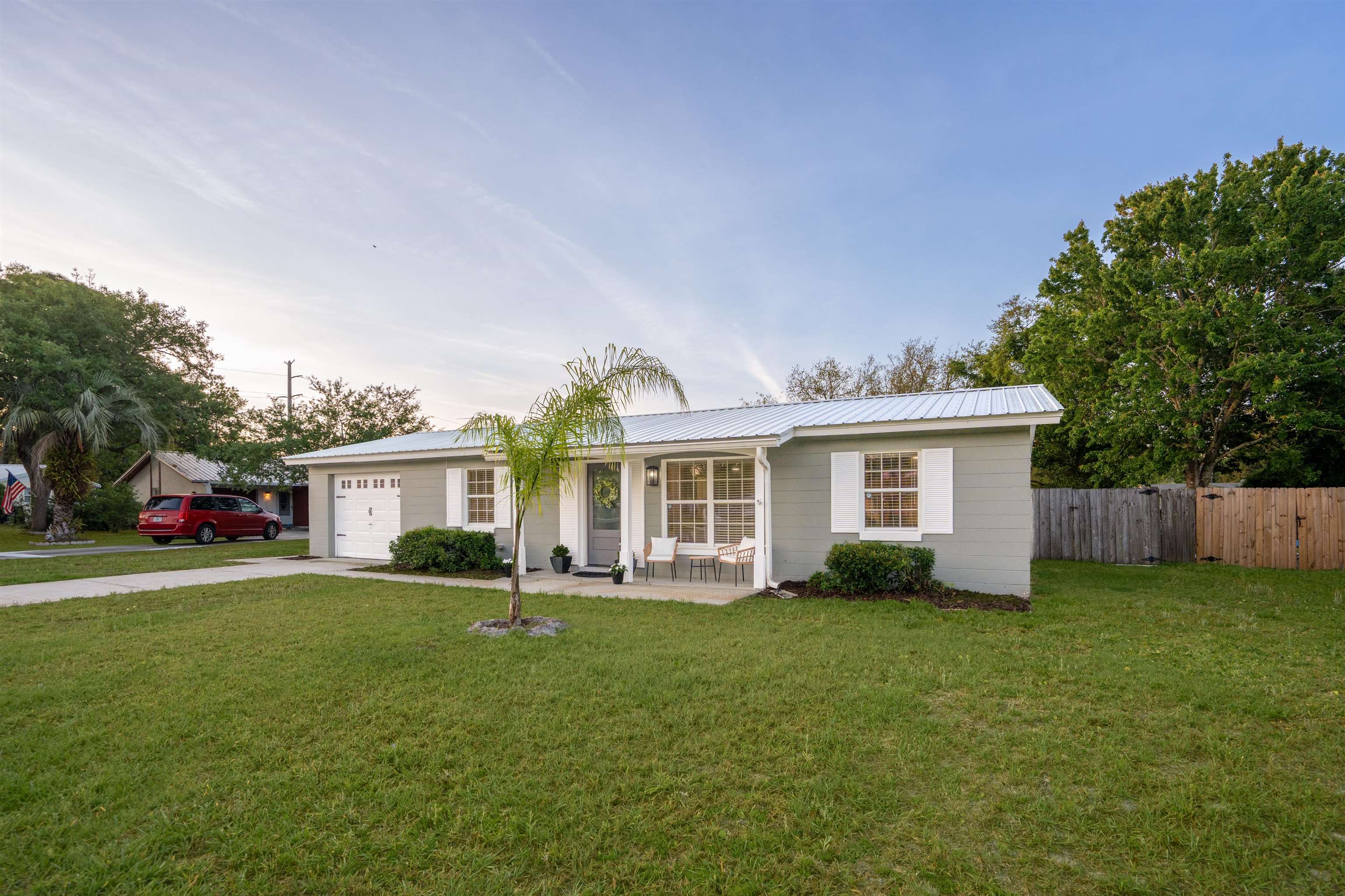 285 Trillo Street St. Augustine, FL 32086 - Photo 2 of 48 Ranch-style house with a garage, concrete driveway, a metal roof, and a porch