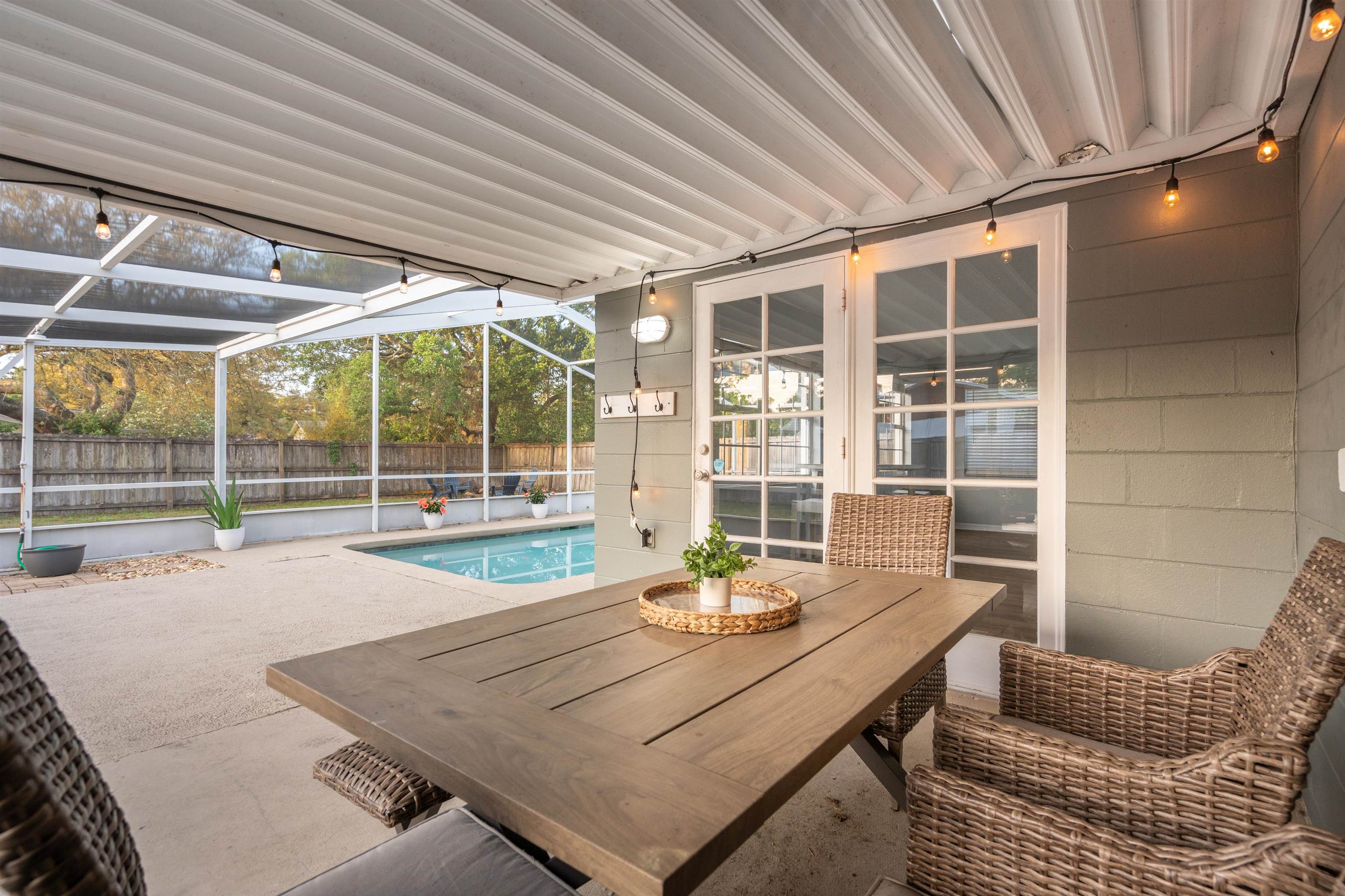 285 Trillo Street St. Augustine, FL 32086 - Photo 23 of 48 View of swimming pool featuring patio surround, outdoor dining space, glass enclosure, french doors, and a sunroom