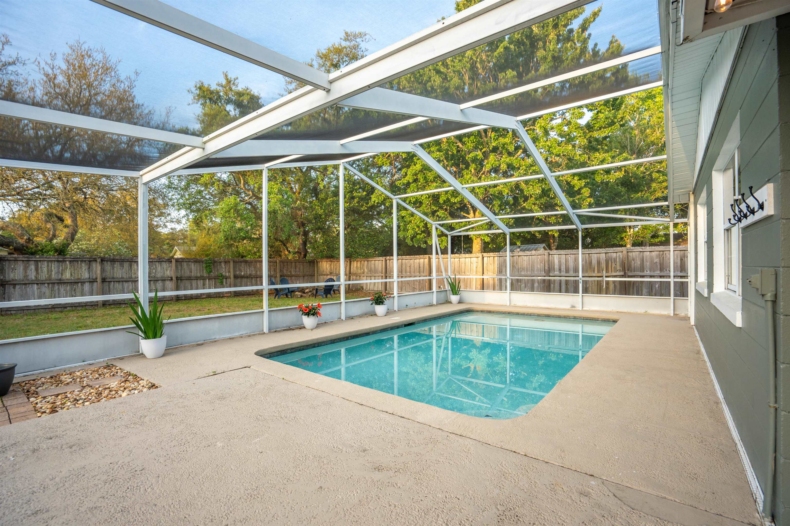285 Trillo Street St. Augustine, FL 32086 - Photo 25 of 48 View of swimming pool featuring glass enclosure, patio surround, a fenced backyard, and a sunroom