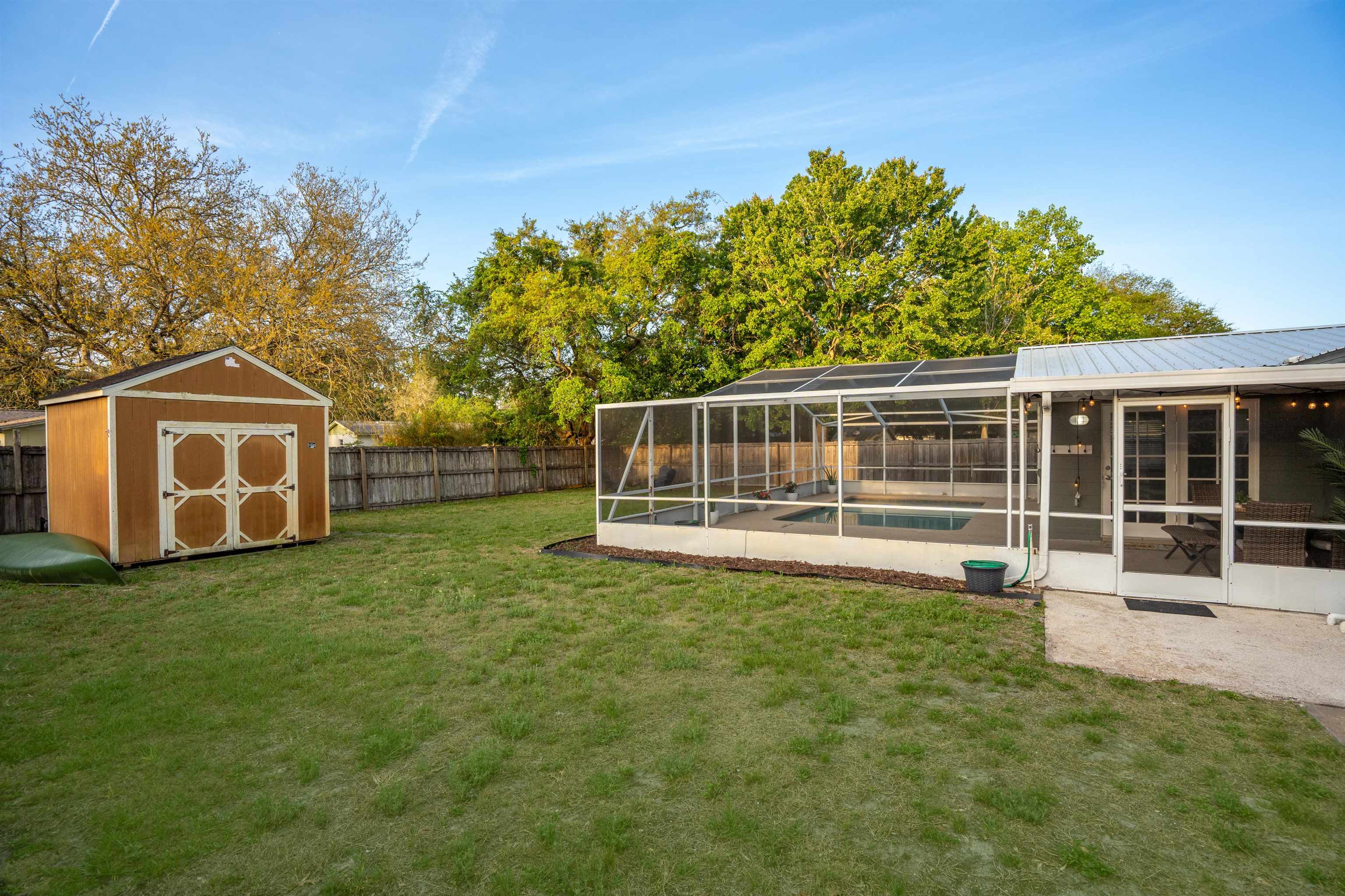 285 Trillo Street St. Augustine, FL 32086 - Photo 28 of 48 Fenced backyard featuring a lanai, a sunroom, and a storage shed