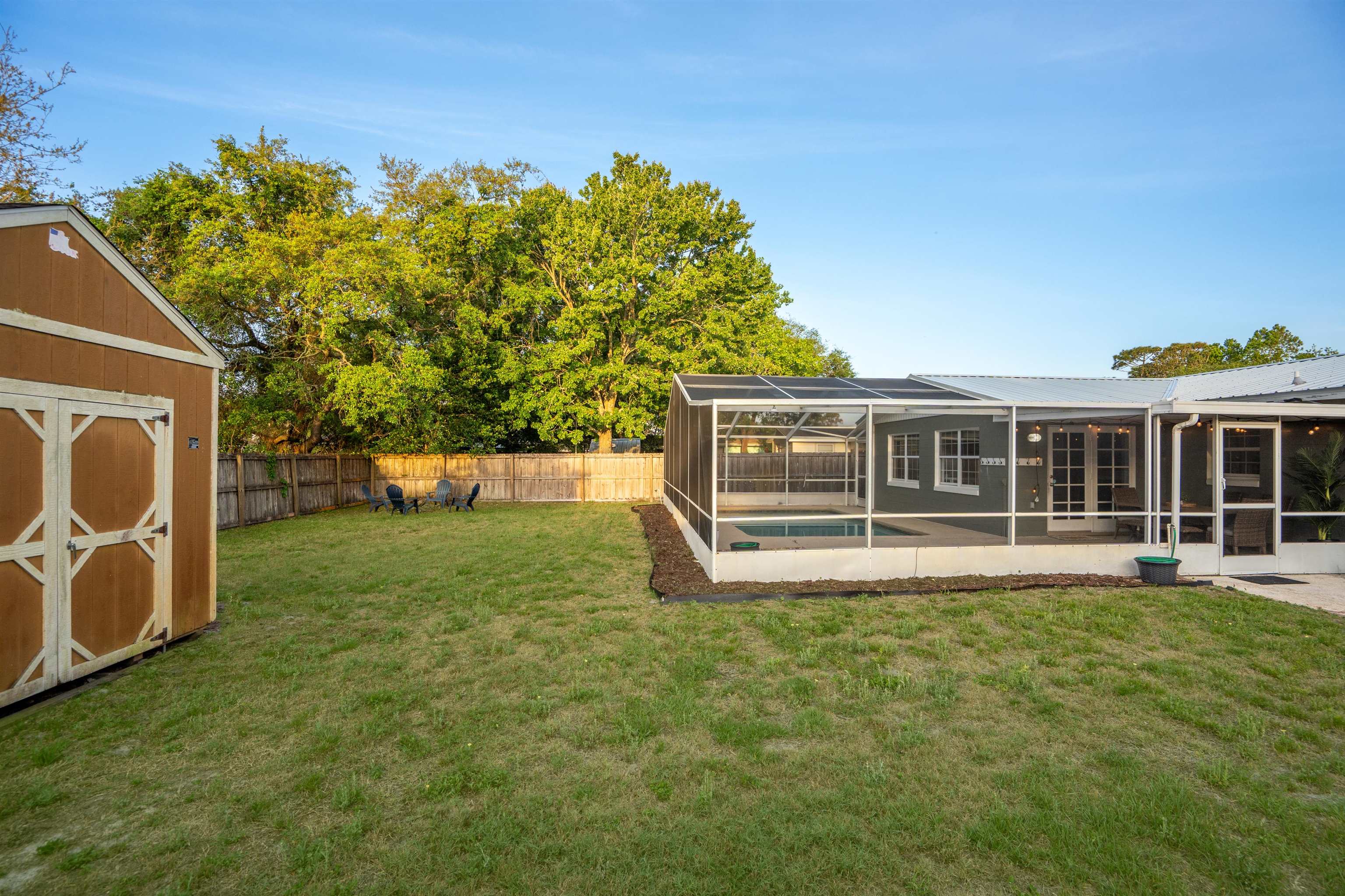 285 Trillo Street St. Augustine, FL 32086 - Photo 29 of 48 Fenced backyard with a sunroom, a storage shed, and a lanai