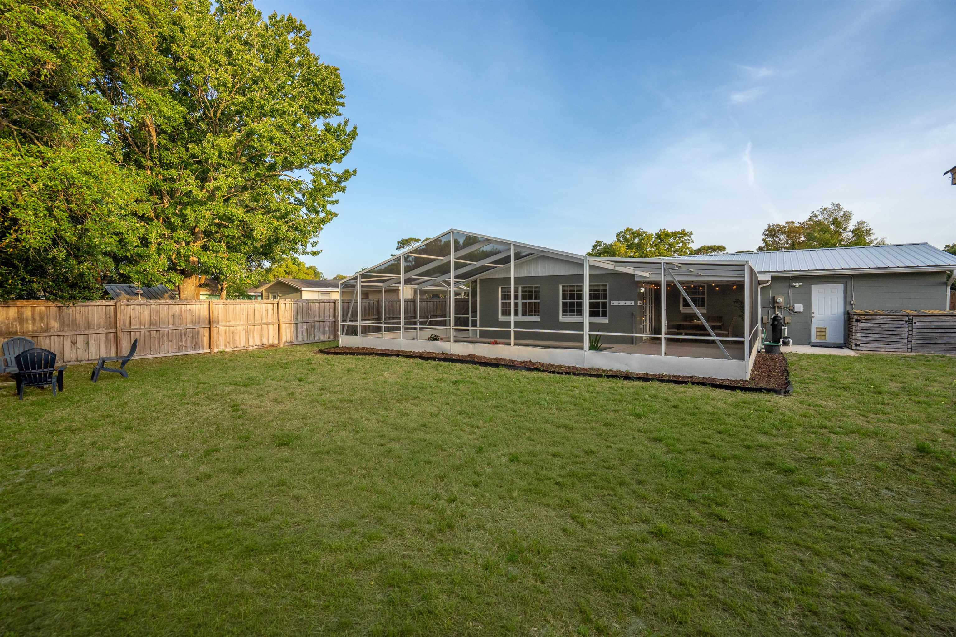 285 Trillo Street St. Augustine, FL 32086 - Photo 30 of 48 Rear view of house with a fenced backyard, glass enclosure, and a sunroom