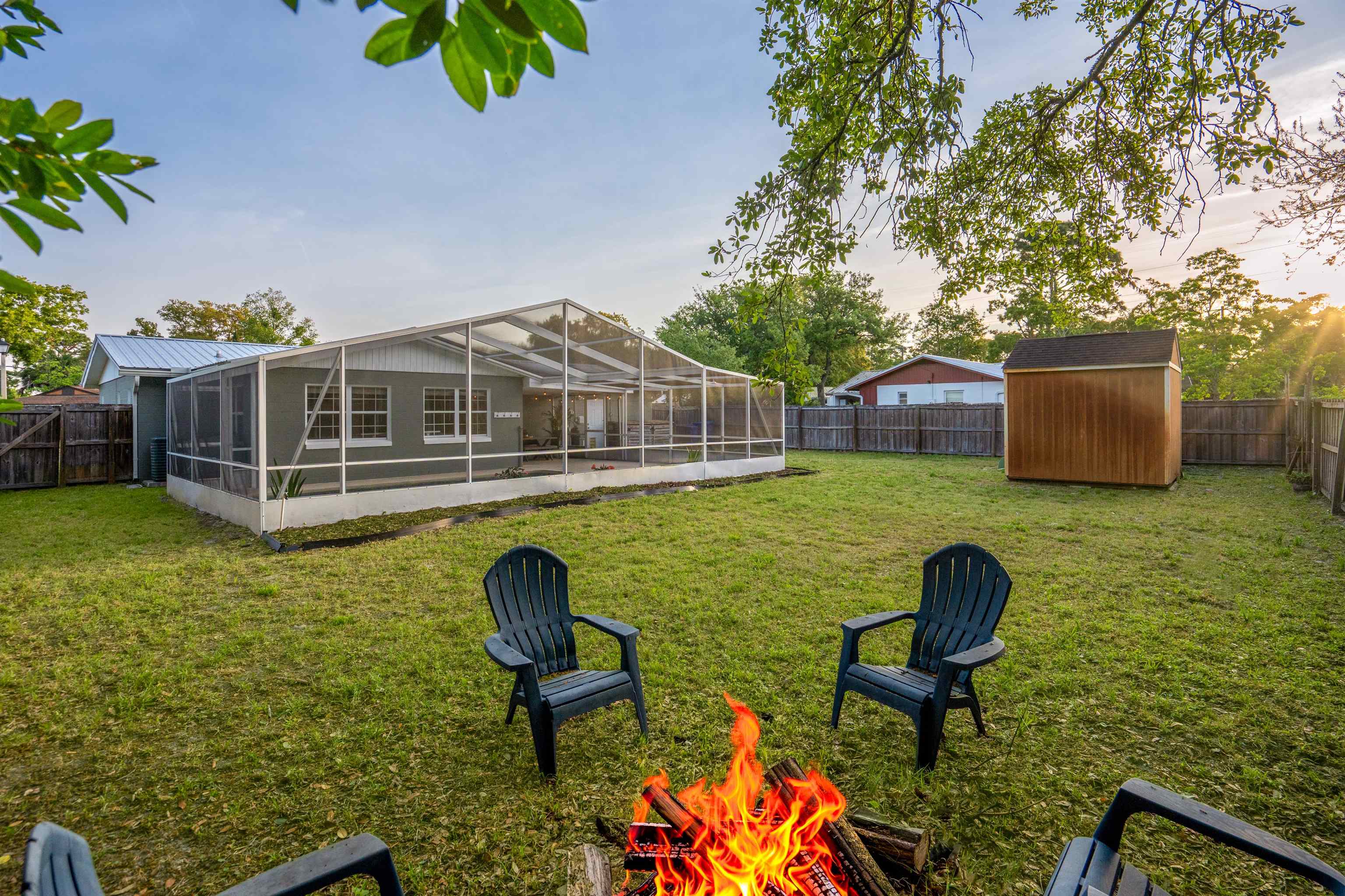 285 Trillo Street St. Augustine, FL 32086 - Photo 31 of 48 Fenced backyard with a lanai, a sunroom, a fire pit, and a storage shed