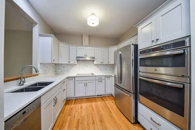 a kitchen with granite countertop stainless steel appliances and wooden cabinets