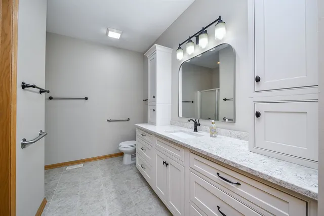 a spacious bathroom with a granite countertop sink mirror and a toilet