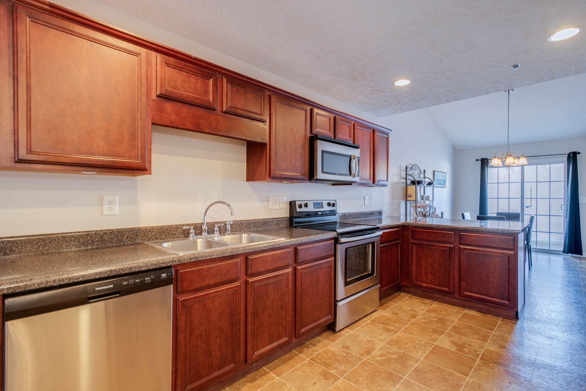 3057 Soaring Eagle Way Spring Hill, TN 37174 - Photo 6 of 32 a kitchen with stainless steel appliances granite countertop a sink stove and cabinets