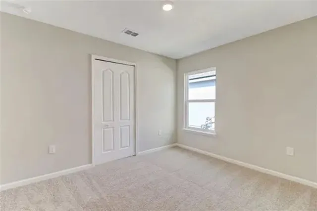 an empty room with windows and closet