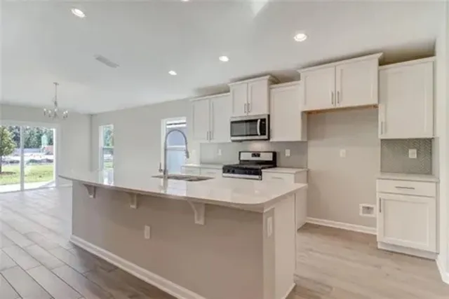 a kitchen with kitchen island a white counter top space cabinets and stainless steel appliances