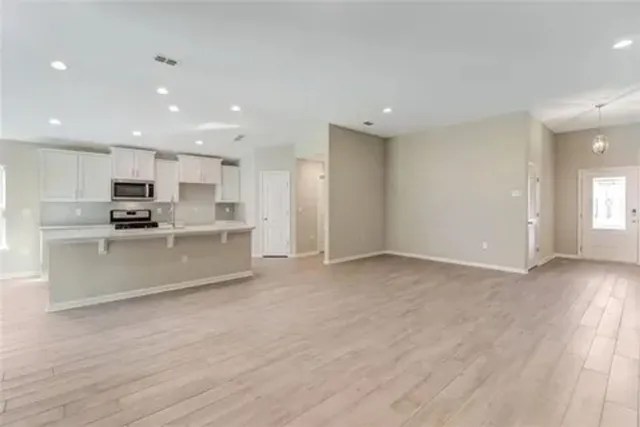 a view of kitchen with granite countertop stainless steel appliances refrigerator sink and cabinets