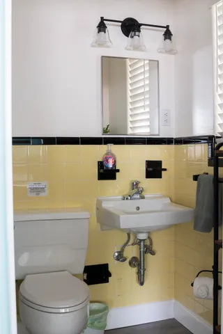 a bathroom with a sink a toilet and mirror
