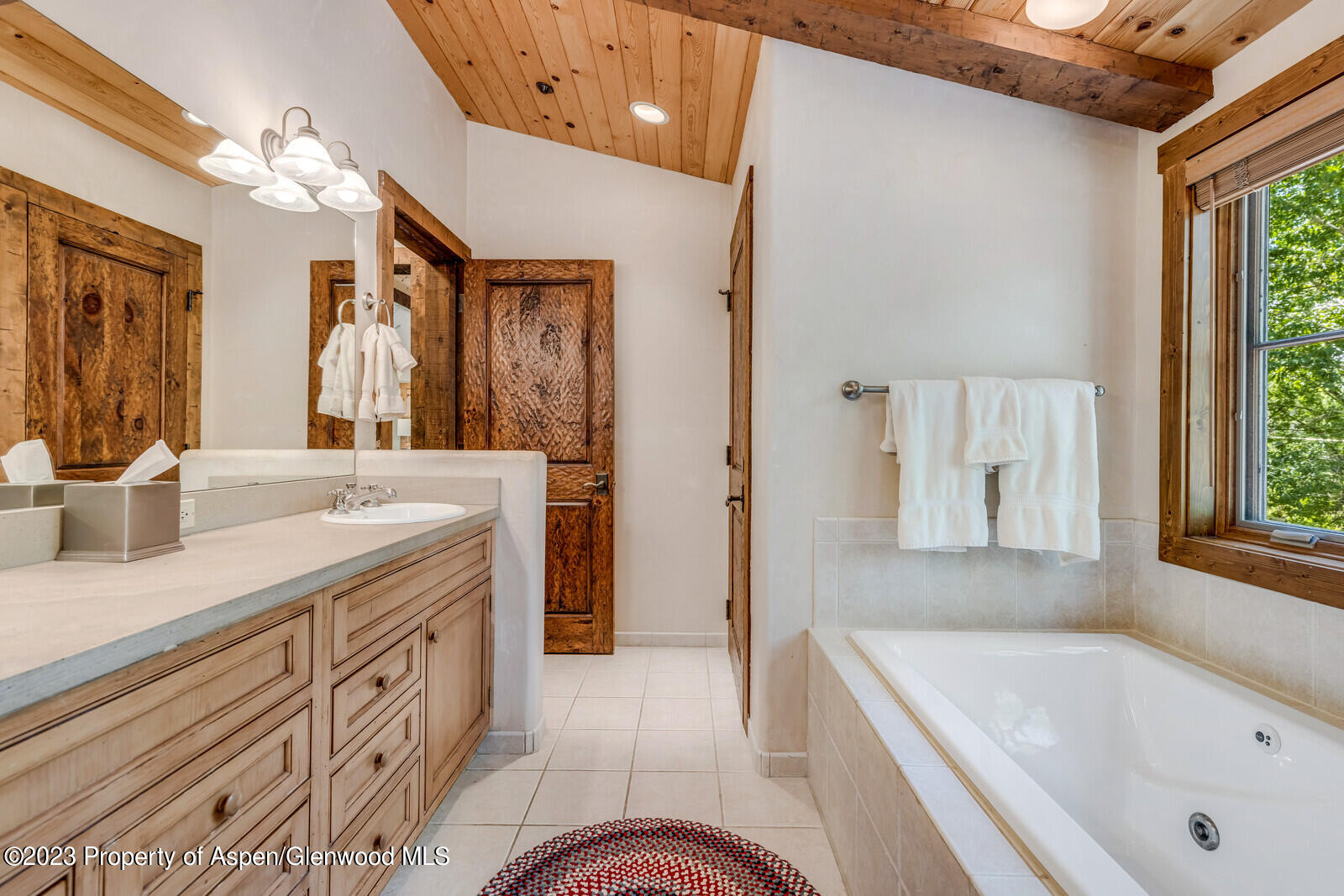 6 A Arbaney Ranch Road Basalt, CO 81621 - Photo 24 of 44 a bathroom with a tub a sink and a large mirror