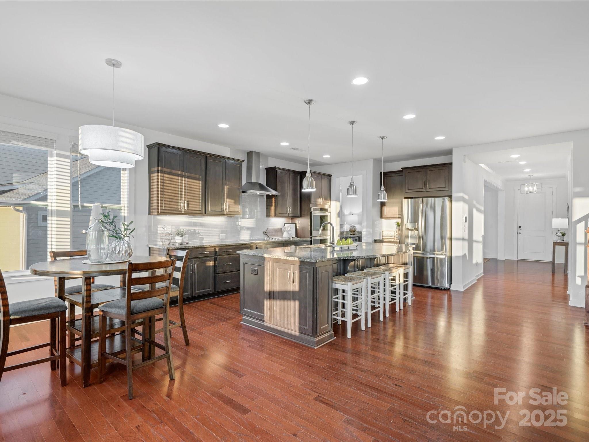 523 Rock Skip Way Fort Mill, SC 29708 - Photo 13 of 48 a kitchen with a dining table chairs wooden floor stainless steel appliances and cabinets