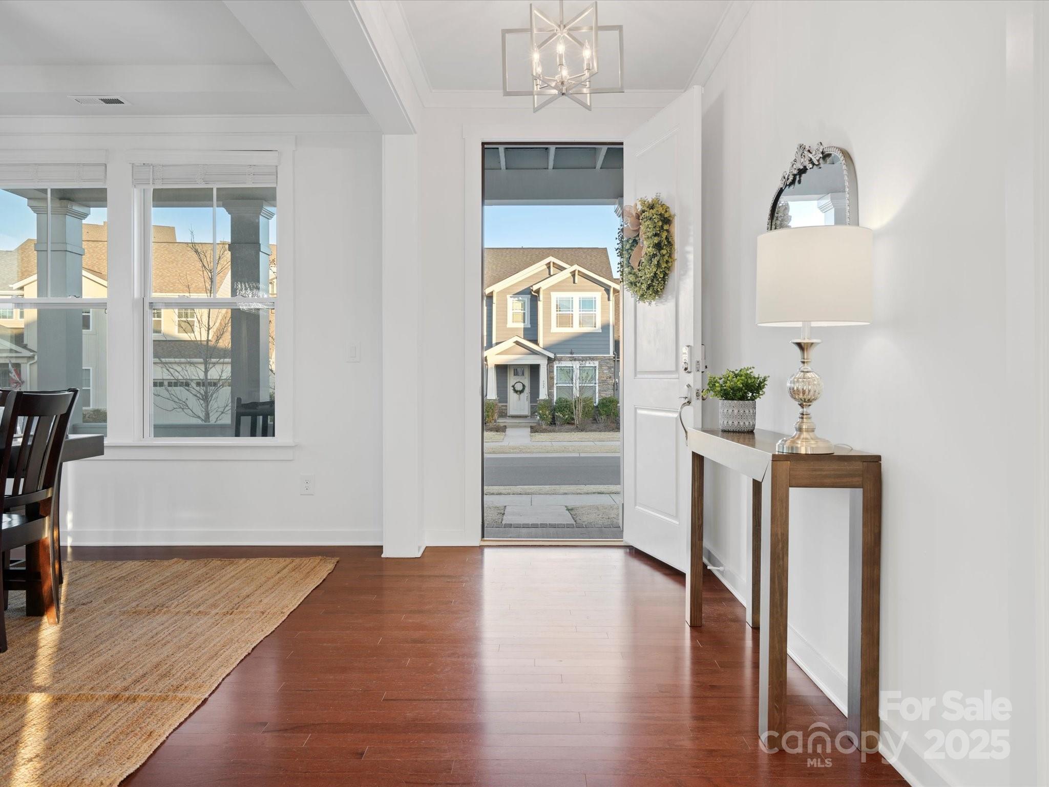 523 Rock Skip Way Fort Mill, SC 29708 - Photo 3 of 48 a hallway with wooden floor windows and a kitchen