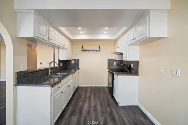 a kitchen with sink a microwave and cabinets