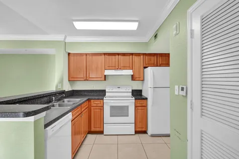 a kitchen with stainless steel appliances granite countertop a stove a sink and a refrigerator