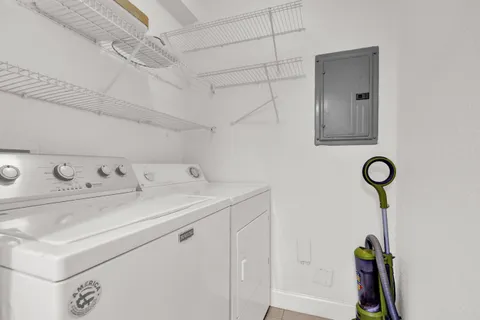 a utility room with cabinets washer and dryer