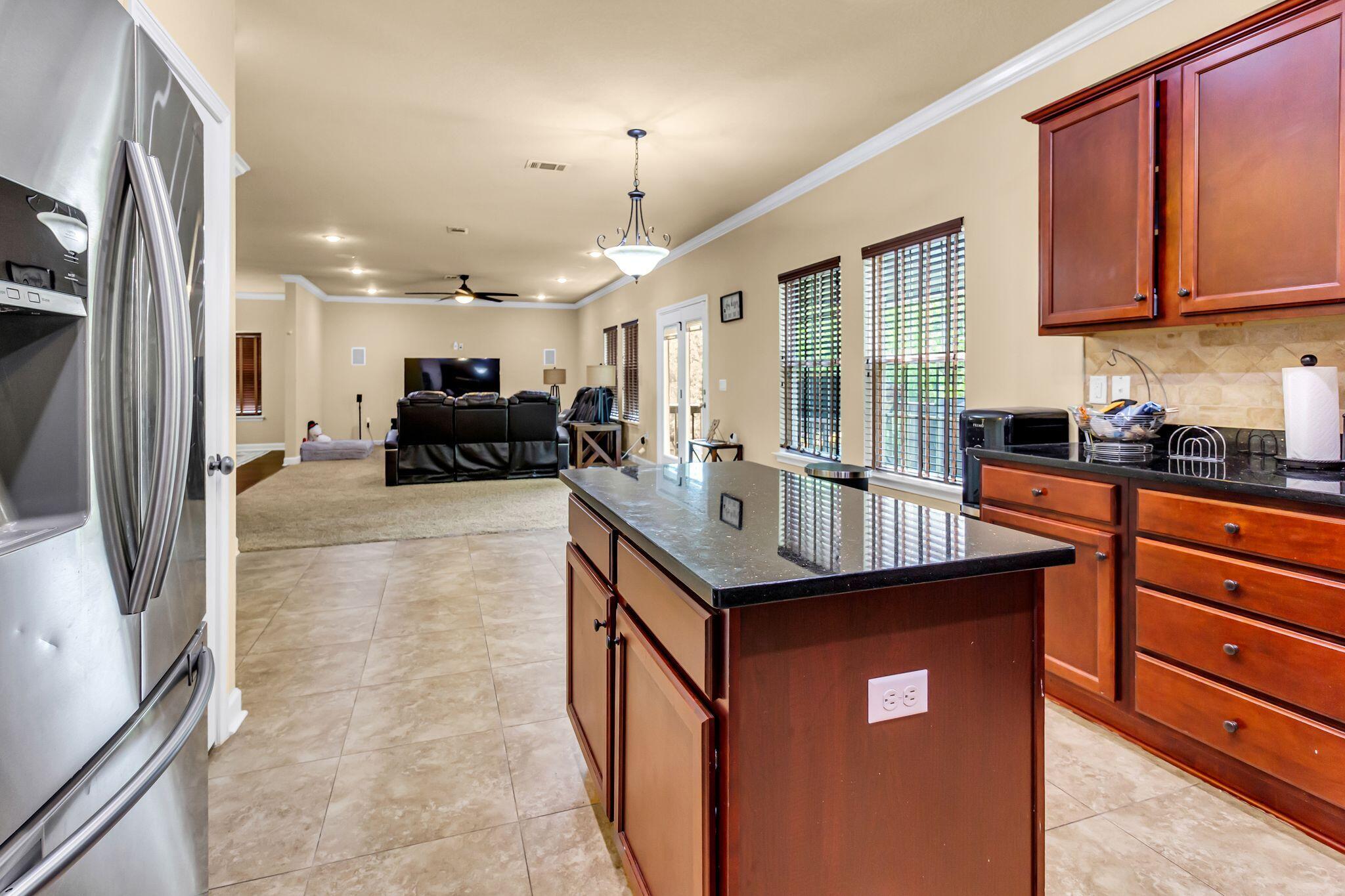 4558 Hermosa Road Crestview, FL 32539 - Photo 16 of 50 a kitchen with kitchen island granite countertop a sink and refrigerator