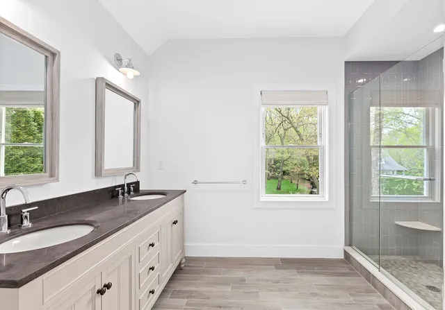 a bathroom with a double vanity sink and a window