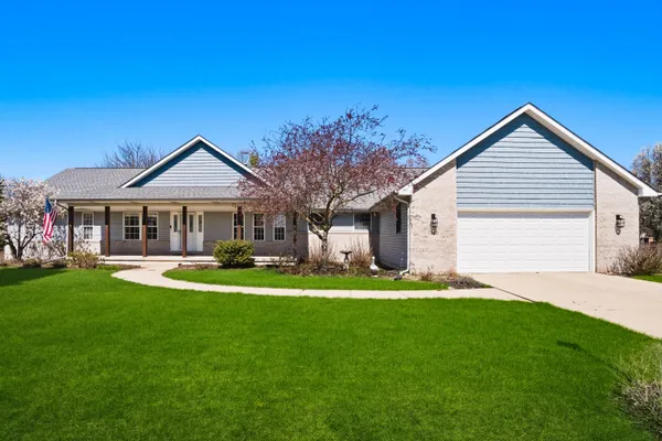 a front view of a house with a garden and patio