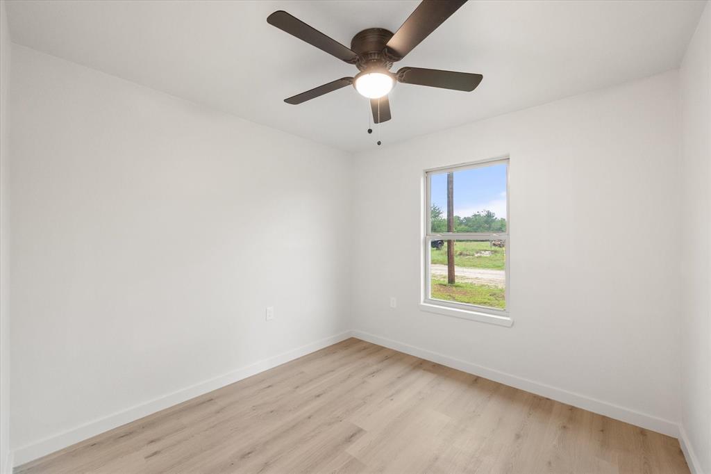 901 South 3rd Dawson, TX 76639 - Photo 15 of 32 an empty room with a window and a ceiling fan