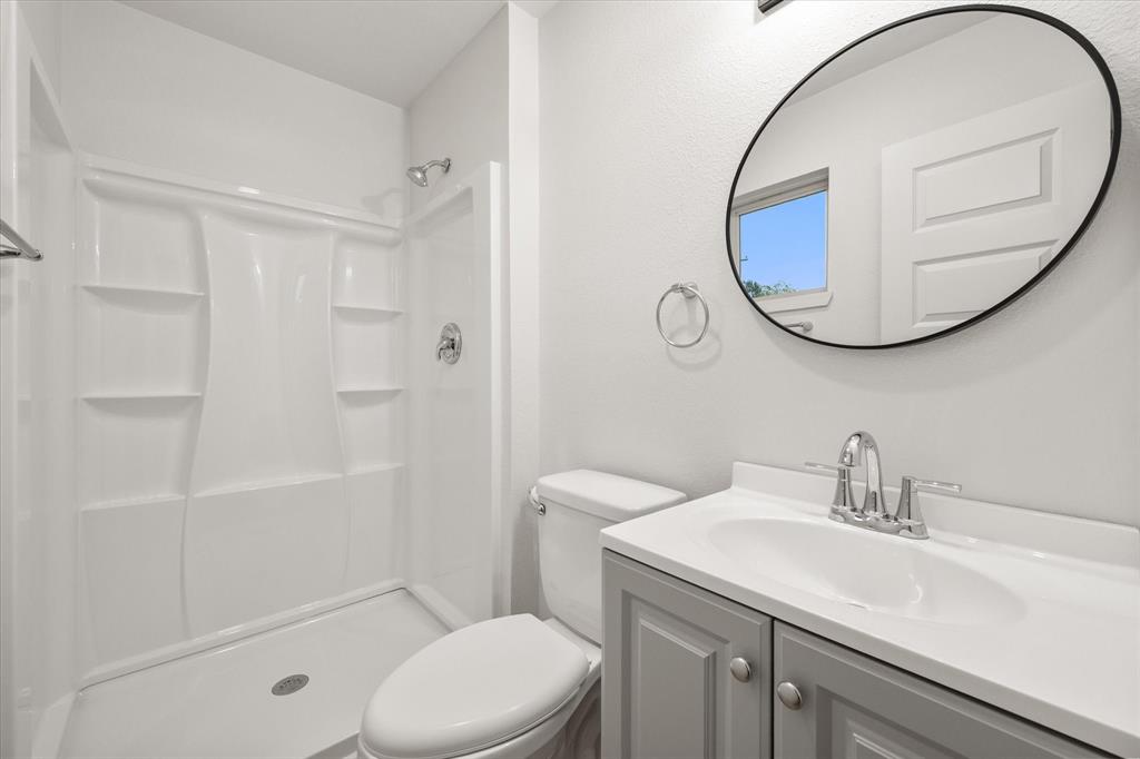 901 South 3rd Dawson, TX 76639 - Photo 18 of 32 a bathroom with a sink a mirror a toilet and shower