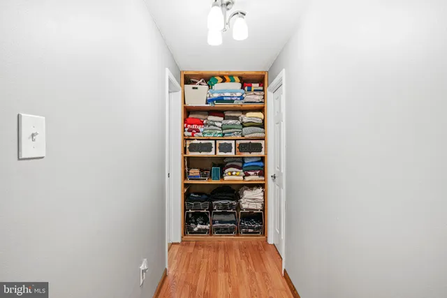 a view of a hallway with wooden floor and a window