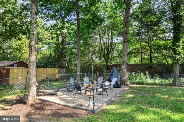 a view of a chair and table in backyard of the house