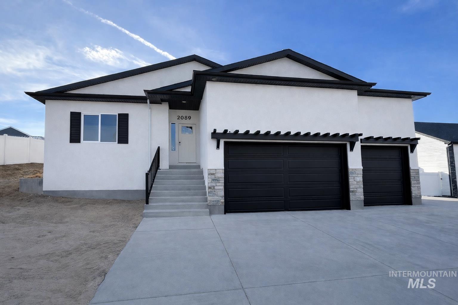 2089 Magellan Loop Pocatello, ID 83204 - Photo 1 of 1 View of front of property featuring stone siding, stucco siding, and concrete driveway