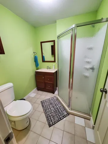 a bathroom with a granite countertop toilet and a shower