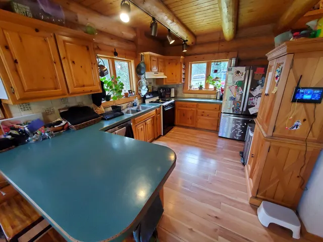 a kitchen with stainless steel appliances granite countertop a sink a stove counter space and wooden floor