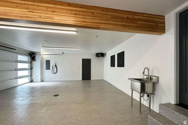 11454 South Oberland Road Sandy, UT 84092 - Photo 65 of 103 Attached garage with wood-finish beam, light-colored floor coating, and a utility sink