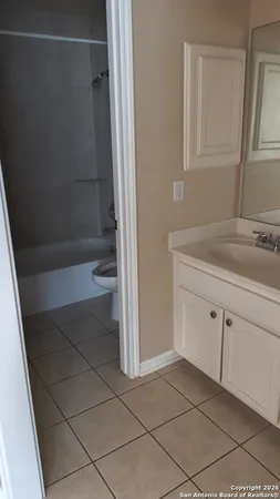 a bathroom with a granite countertop sink a toilet and shower