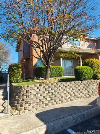 a front view of a house with a tree