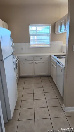 a kitchen with a sink a stove cabinets and a window