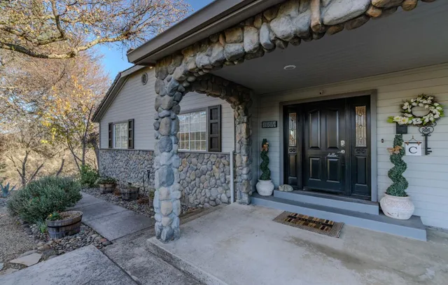 a living room with furniture a large window and wooden floor